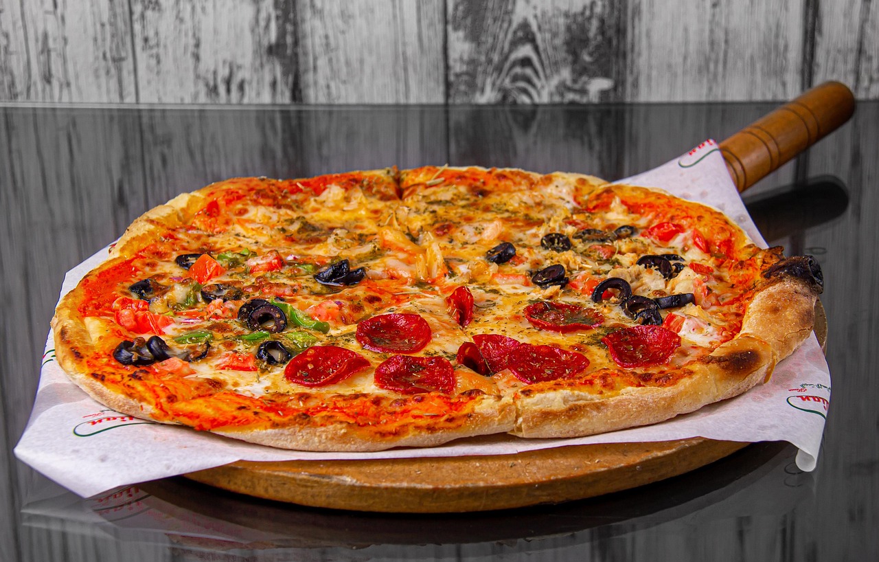 Delicious Pepperoni and Olive Pizza on Wooden Paddle