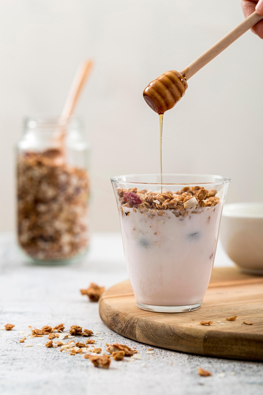 Honey Drizzling Over Yogurt and Granola in Glass