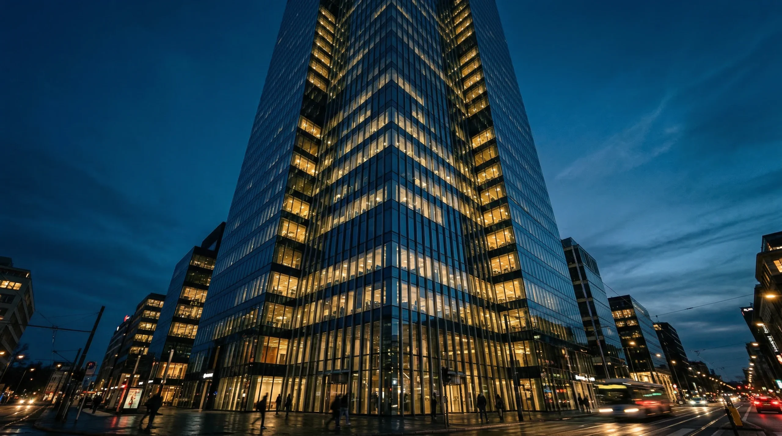 Illuminated Glass Skyscraper at Dusk in Urban Cityscape