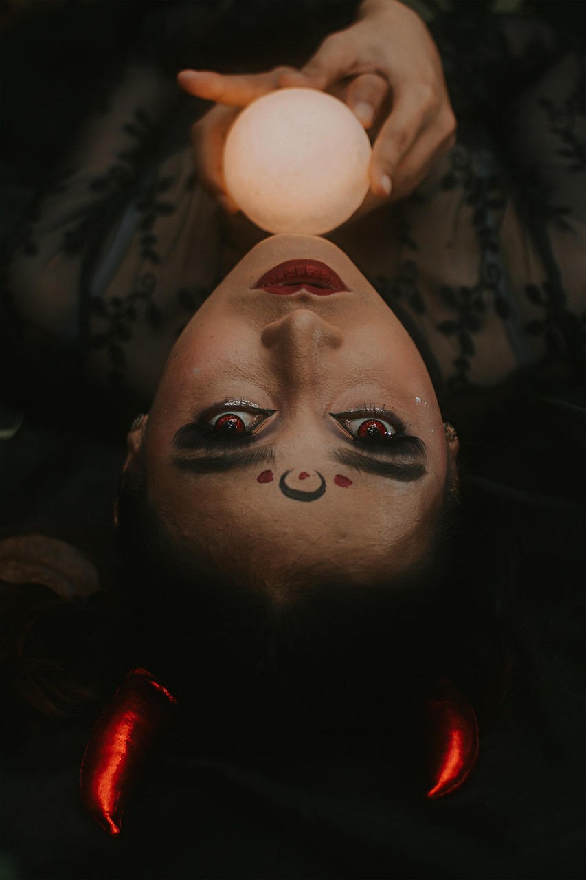 Mystical Woman with Red Horns Holding Glowing Orb