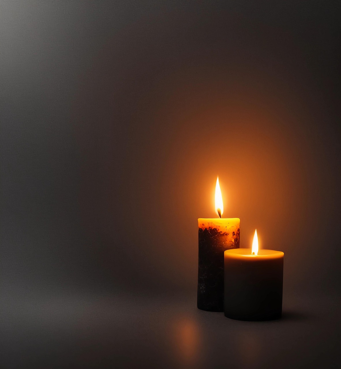 Two Lit Candles Casting Warm Glow in Dark Setting
