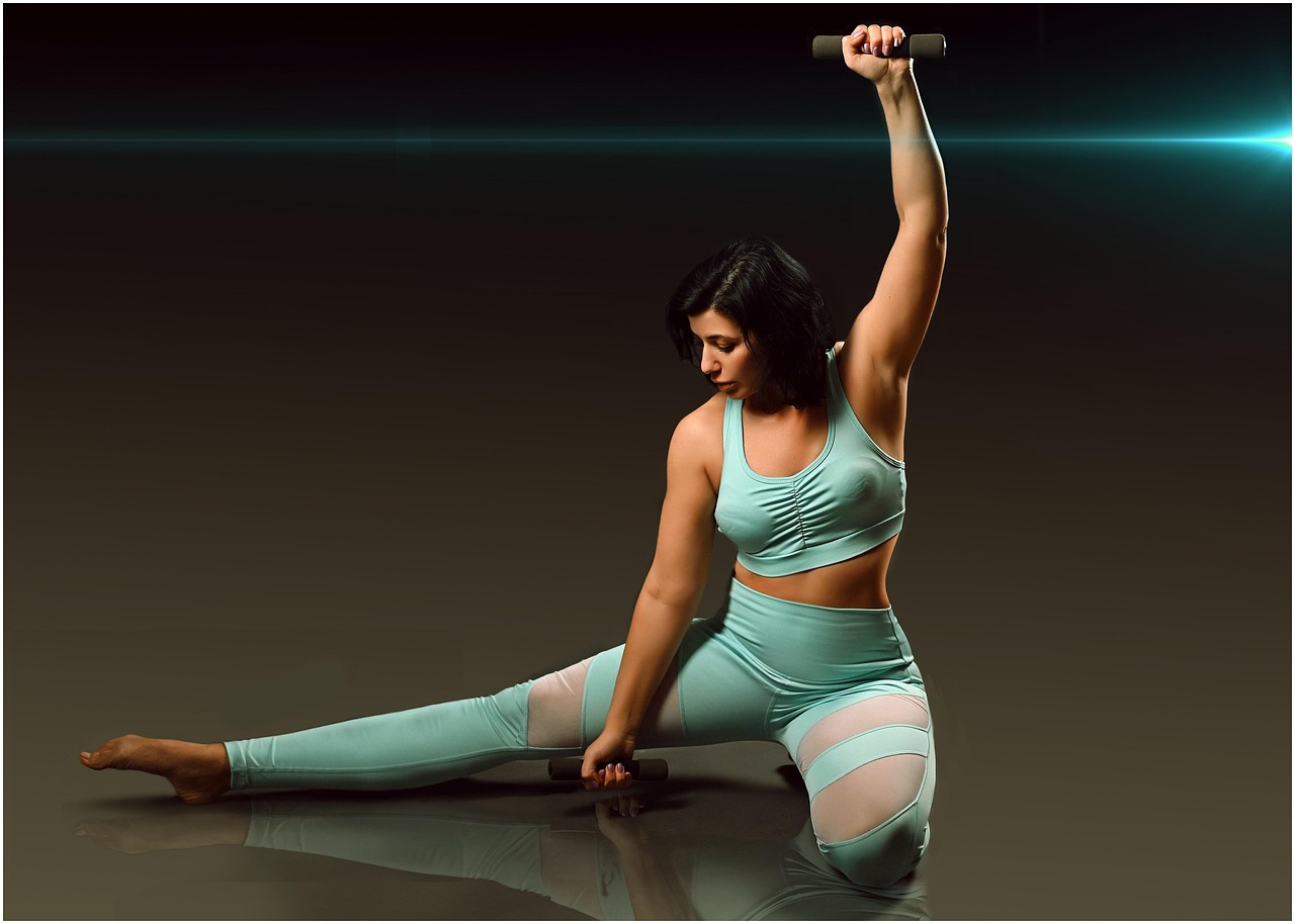 Woman in Aqua Fitness Outfit Stretching with Dumbbells