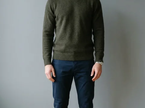 Casual Portrait of Man Standing Against Grey Wall