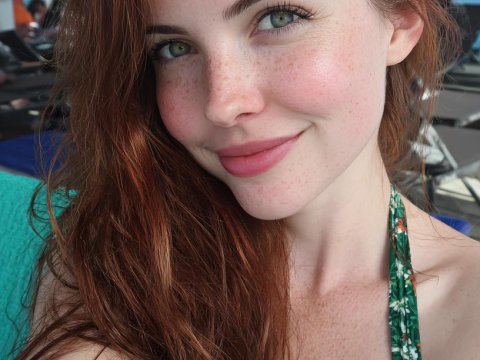 Close-up Portrait of a Smiling Redhead Woman with Freckles