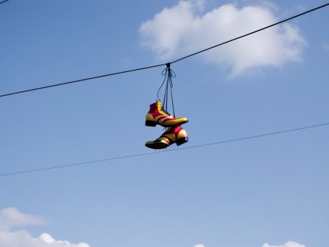 Colorful Shoes Hanging on Power Line Against Blue Sky
