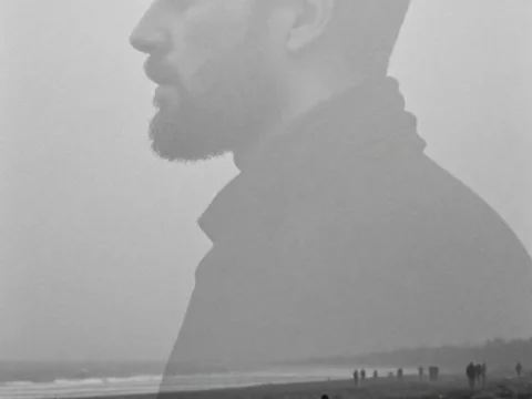 Contemplative Bearded Man Overlaid on Misty Beach Scene