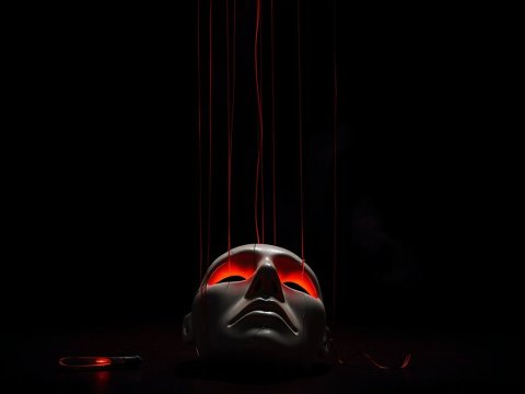 Cracked Puppet Head with Glowing Red Eyes and Strings