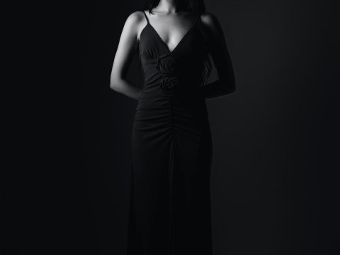 Elegant Woman in Black Evening Gown with Dramatic Lighting