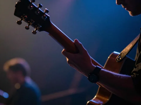 Guitarist Playing on Stage with Moody Lighting