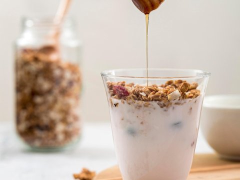 Honey Drizzling Over Yogurt and Granola in Glass