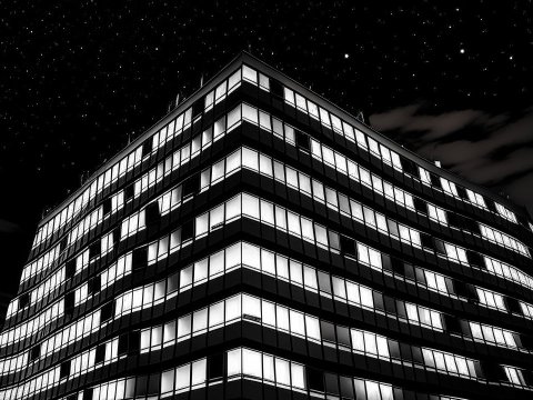Illuminated Office Building at Night Under Starry Sky