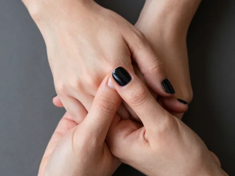 Intertwined Hands with Black Nail Polish