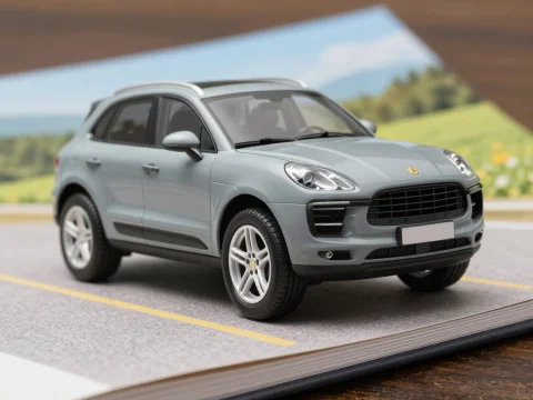 Miniature Porsche SUV Model on Open Book