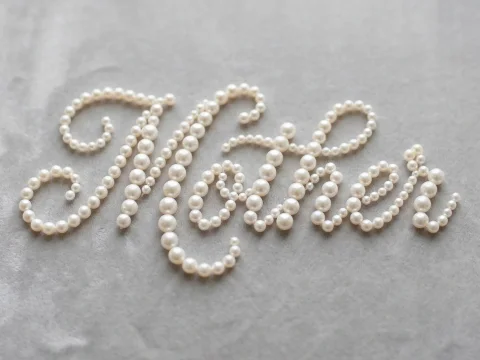 Mother Word Crafted from Pearls on Soft Fabric