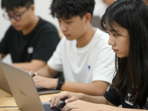 Students Focused on Laptops in Classroom Setting