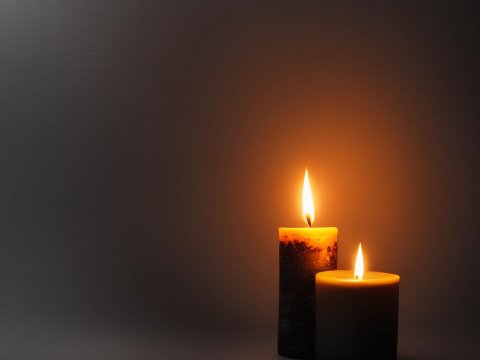 Two Lit Candles Casting Warm Glow in Dark Setting