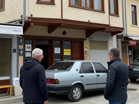 Two Men Observing a Parked Car on a Quiet Street