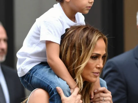 Woman Carrying Child on Shoulders in Urban Setting