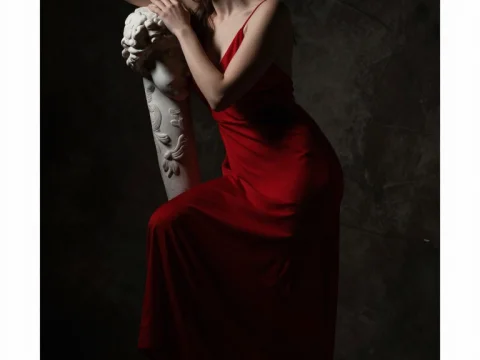 Woman in Red Dress Posing with Classical Sculpture in Chiaroscuro