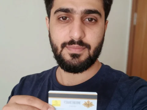 Young Man Holding Card in Home Selfie