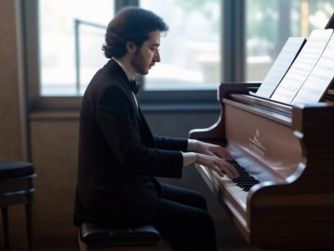 Young Man Playing Piano in Elegant Setting
